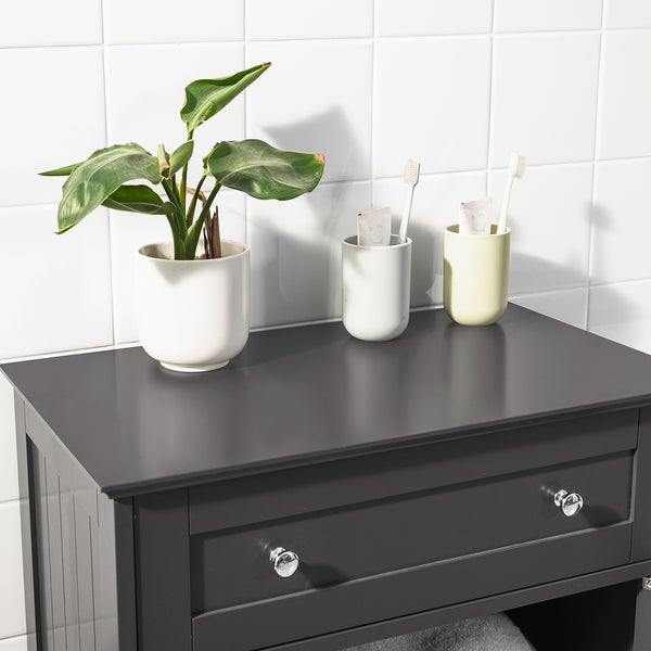 Badezimmer Waschbeckenunterschrank mit Pflanze und Zahnputzbechern