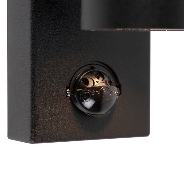 Nahaufnahme eines integrierten Bewegungssensors an einer schwarzen Außenwandleuchte.