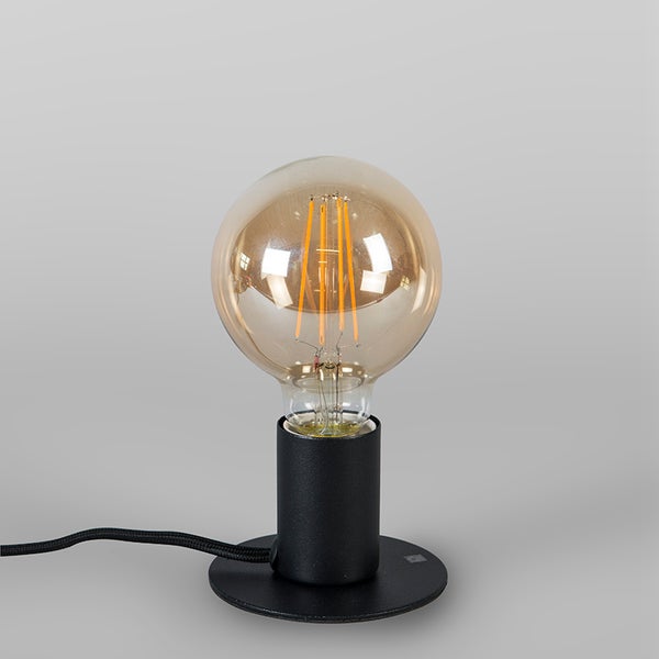 Schwarze Tischleuchte mit einer großen runden LED-Filament-Glühbirne im Vintage-Stil und einem schwarzen Stoffkabel.