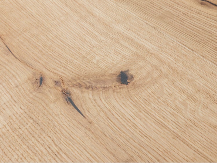 Detailansicht einer Eichenholzoberfläche mit natürlicher Maserung und Astlöchern.