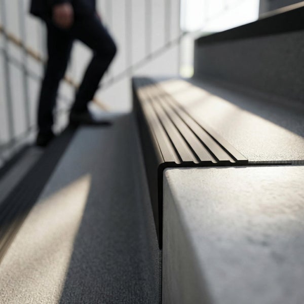 Treppenkantenprofil mit gerillter Oberfläche für Rutschfestigkeit auf einer Treppe aus Stein.