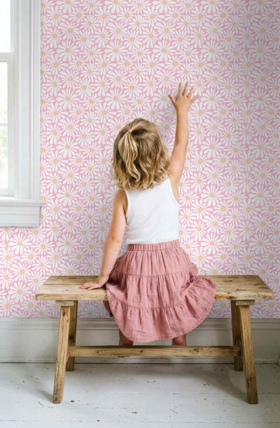 Tapete mit Gänseblümchen-Muster in einem hellen Kinderzimmer mit Holzbank und einem Fenster.