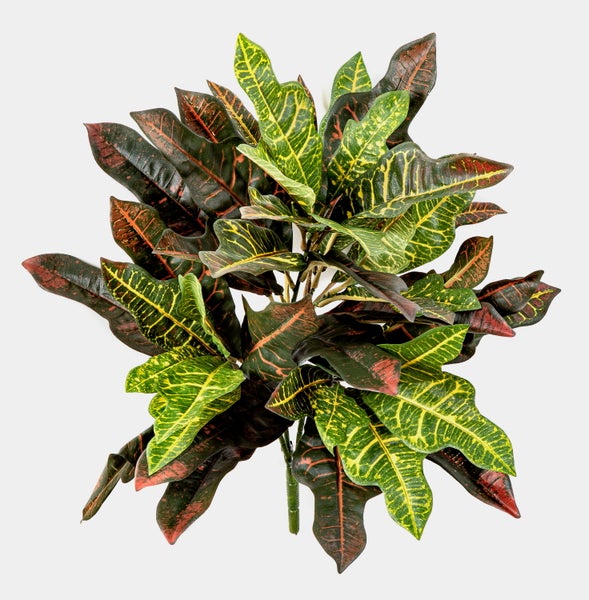 Künstliche Pflanze Croton mit bunt gemusterten Blättern in Grün, Gelb und Rotbraun.