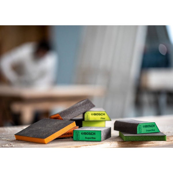 Mehrere Schleifschwämme der Marke Bosch auf einem Holztisch