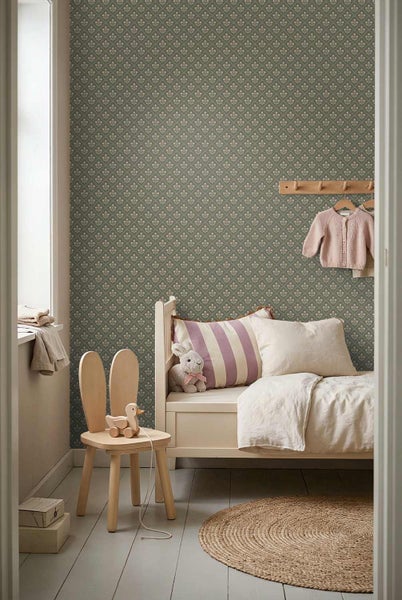 Kinderzimmer mit einer gemusterten Tapete mit kleinen Blumen auf grünem Hintergrund, einem weißen Holzbett und einem hölzernen Hasenstuhl.