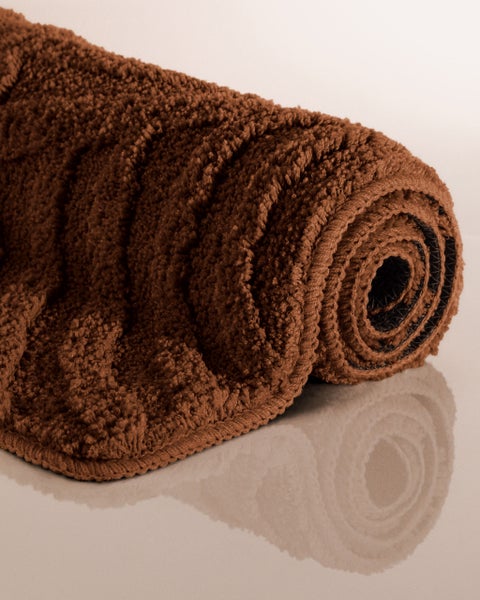 Runder Badeteppich braun mit Wellenmuster und Detailansicht der weichen Textur.