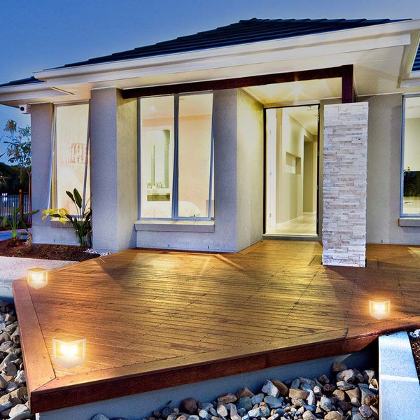 Haus mit Holzterrasse und dekorativer Beleuchtung