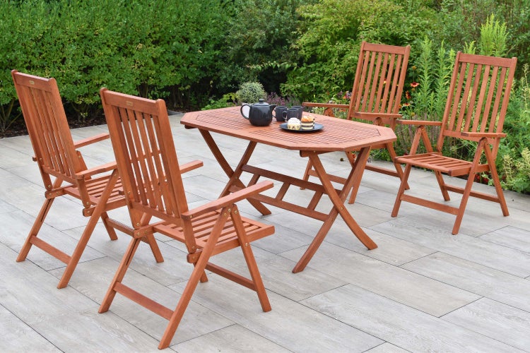 Gartenszene mit Holztisch und vier Holzstühlen auf einer Terrasse