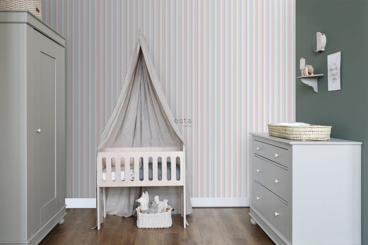 Kinderzimmer mit Gitterbett, Wickelkommode, Schrank und gestreifter Tapete