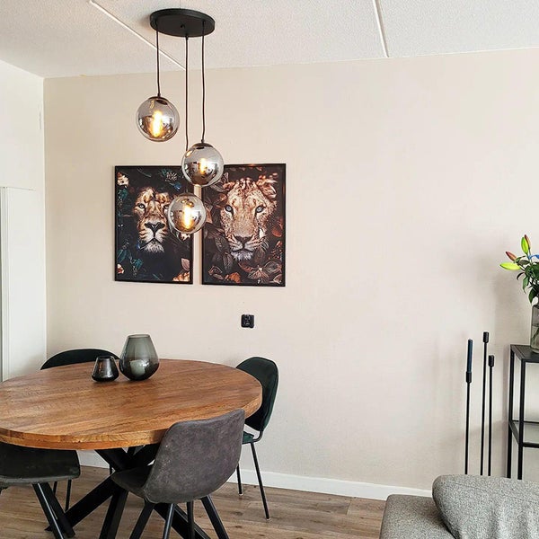 Esszimmer mit Holztisch, Stühlen und Hängelampe mit drei Glaskugeln