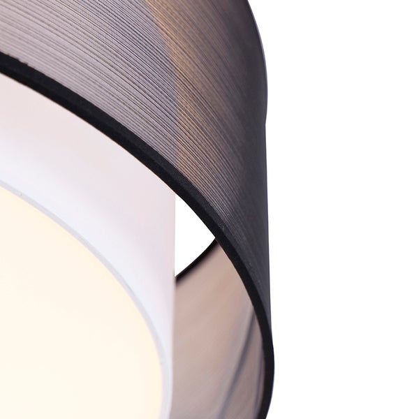 Nahaufnahme eines Lampenschirms mit schwarzem Stoffschirm und weißem Innenschirm einer Deckenleuchte.