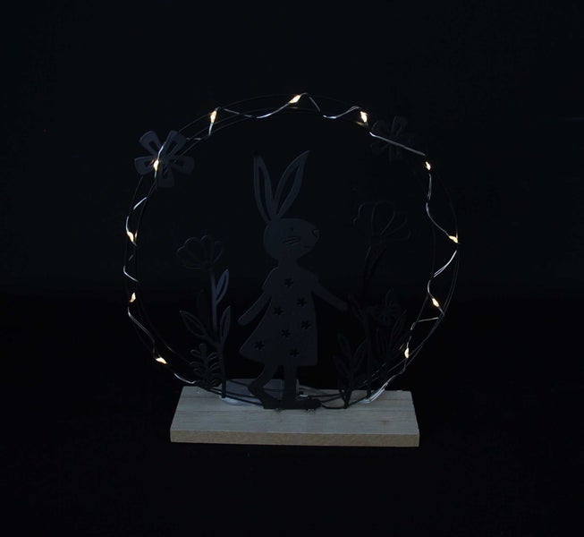 Dekorative Osterdekoration mit Hasenmotiv und LED-Lichtern auf Holzsockel