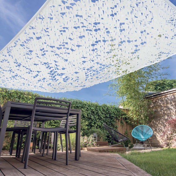 Sonnensegel Camouflage über einer Holzterrasse mit Gartenmöbeln, umgeben von Pflanzen und Bambus.