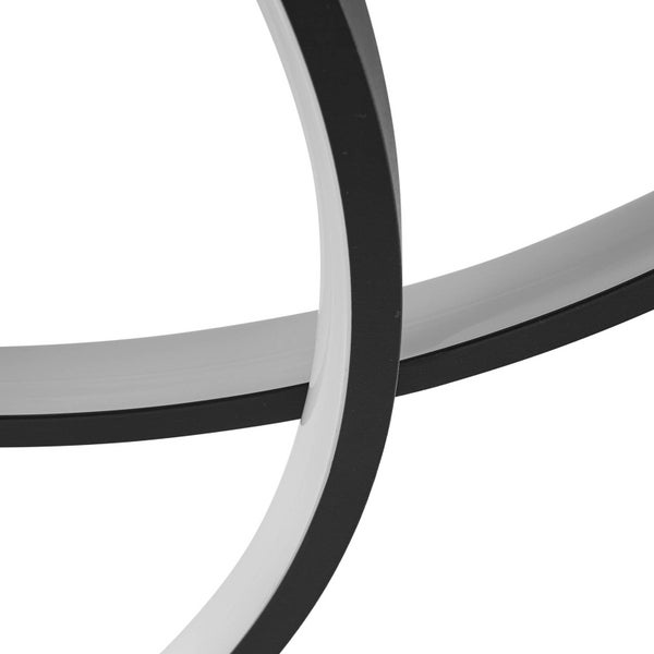 Detailansicht einer modernen LED-Deckenleuchte mit sich kreuzenden schwarzen und weißen bogenförmigen Elementen.