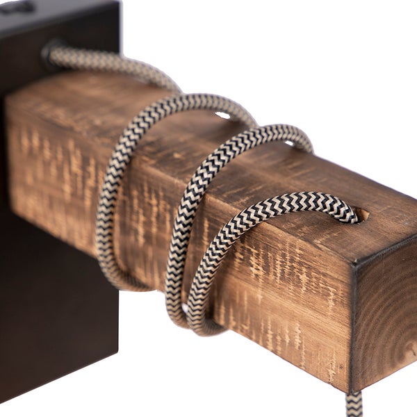 Detailansicht einer Wandleuchte mit Holzbalken und Textilkabel