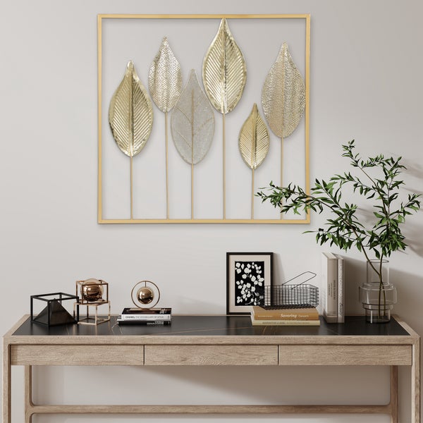 Dekorative goldfarbene Wanddekoration mit Blattmotiv über einem Schreibtisch
