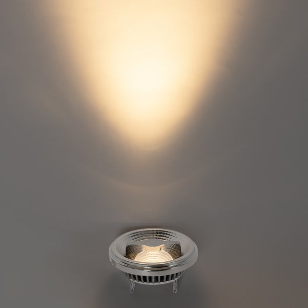 LED-Leuchtmittel mit warmweißem Lichtkegel an einer Wand.