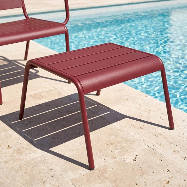 Moderner Gartenhocker oder Beistelltisch aus Metall mit Lattenoberfläche auf einer Terrasse am Pool.