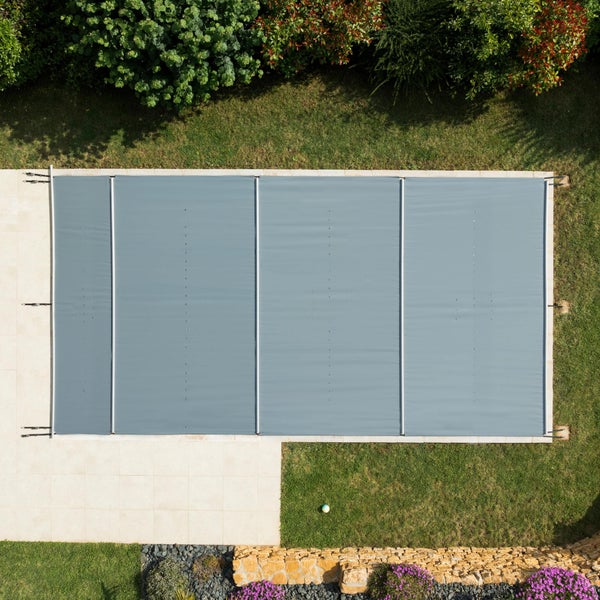 Aufnahme von oben eines Pools mit Poolabdeckung in einem Garten.