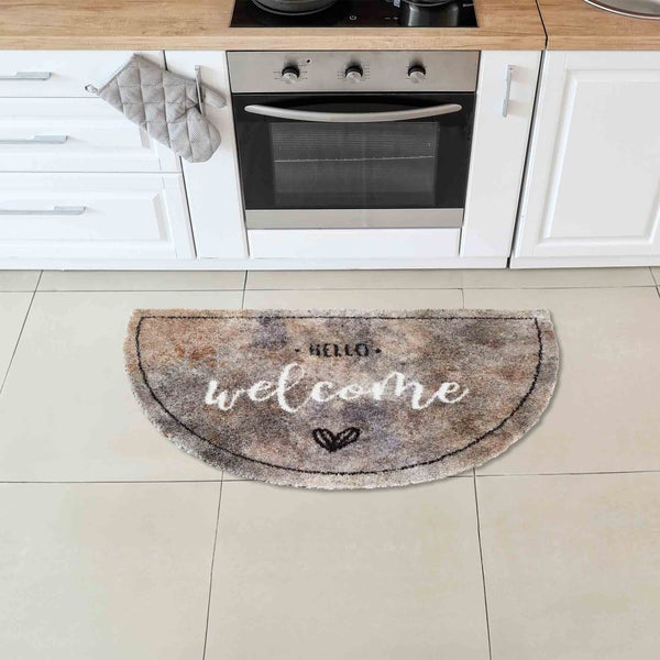 Halbrunde Fußmatte mit der Aufschrift Hello Welcome vor einer Küchenzeile