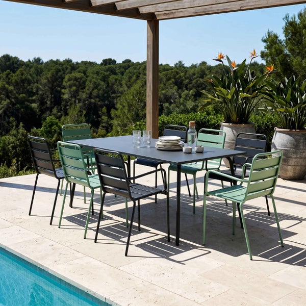 Modernes Gartenmöbel-Set aus Metall mit rechteckigem Tisch und Stühlen auf einer hellen Terrasse am Pool mit Waldblick.
