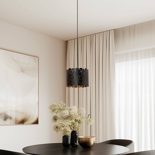 Moderne Esszimmer-Einrichtung mit einer schwarzen Pendelleuchte mit Lasercut-Muster über einem runden dunklen Tisch mit Vasen und Schale.