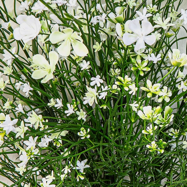 Künstliche Pflanze mit kleinen weißen Blüten und grünen Stielen.