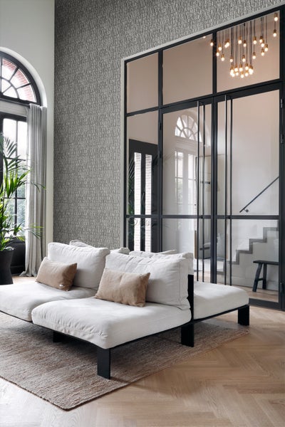 Helles Wohnzimmer mit Sofa, Teppich und gemusterter Tapete