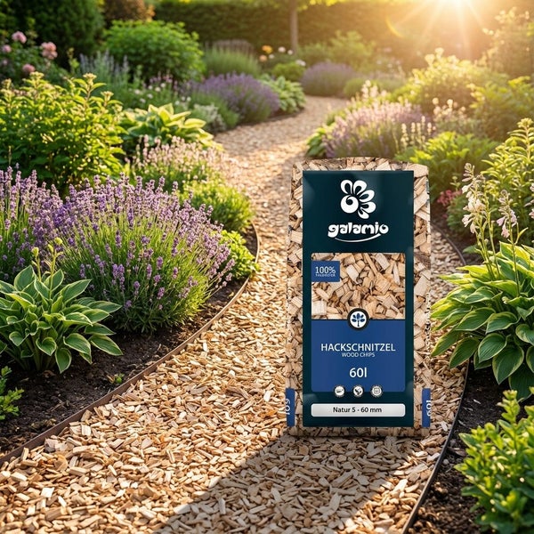Ein Sack Galamio Hackschnitzel steht auf einem Gartenweg, der mit denselben Holzspänen ausgelegt ist, umgeben von blühenden Lavendelbeeten.