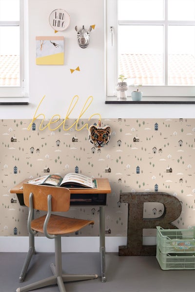 Kinderzimmer mit Tapete im Häuser-Design, Holzbett und gestreiftem Teppich unter einer Dachschräge.