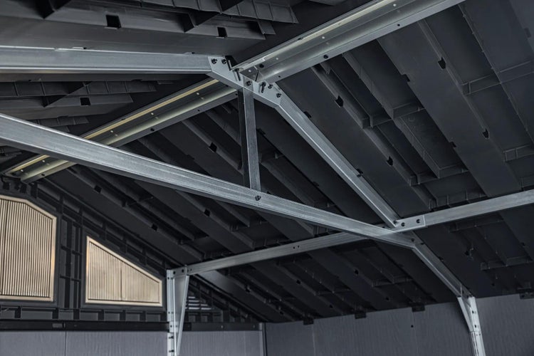 Innenansicht eines Gartenhauses mit Dachkonstruktion aus Metallstreben und Kunststoffpaneelen mit integrierten Fenstern.