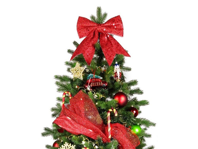 Weihnachtsbaumspitze in Form einer großen Schleife auf einem künstlichen Weihnachtsbaum mit weihnachtlichem Baumschmuck dekoriert.