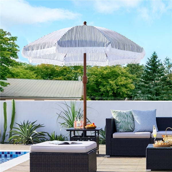 Terrassenszene mit gestreiftem Sonnenschirm und Gartenmöbeln