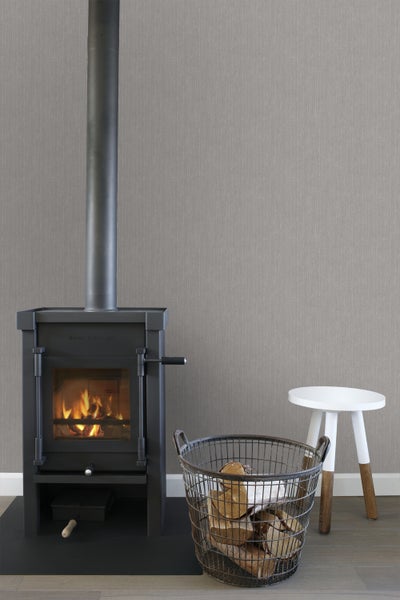 Kaminofen mit Holzkorb und Hocker in einem hellen Raum