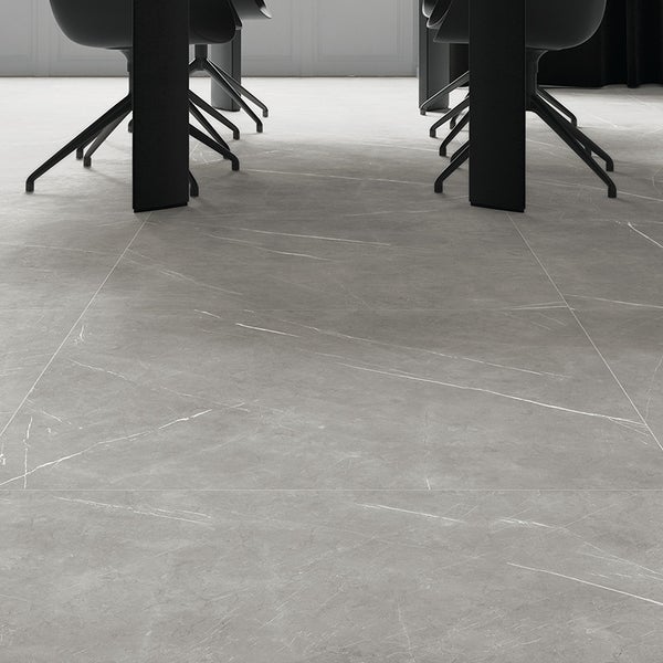 Graue Bodenfliesen in Steinoptik mit feiner Marmorierung in einem modern eingerichteten Essbereich mit schwarzen Stuhlbeinen.