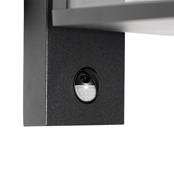Nahaufnahme eines integrierten Bewegungsmelders an einer schwarzen Außenwandleuchte aus Metall.