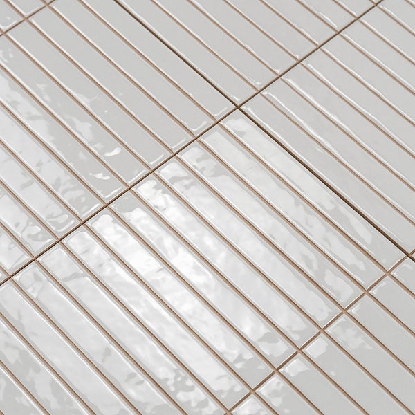 Wandfliesen mit Streifenoptik und glänzender Oberfläche in einer quadratischen Anordnung.