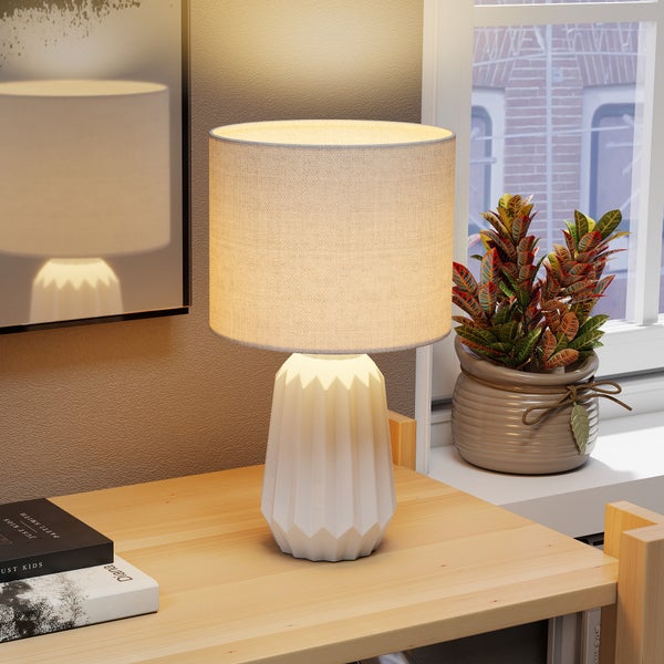 Tischleuchte mit Lampenschirm und geometrischem Sockel