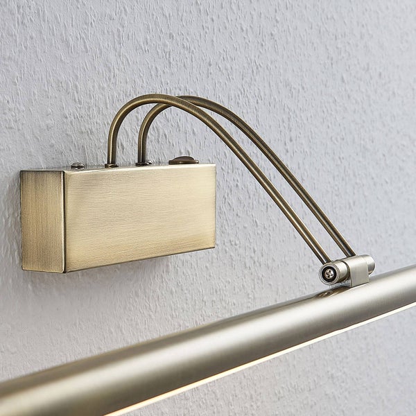 Bilderleuchte aus Metall in Messing-Optik mit rechteckigem Wandgehäuse und zwei gebogenen Armen zur Beleuchtung von Wandbildern.