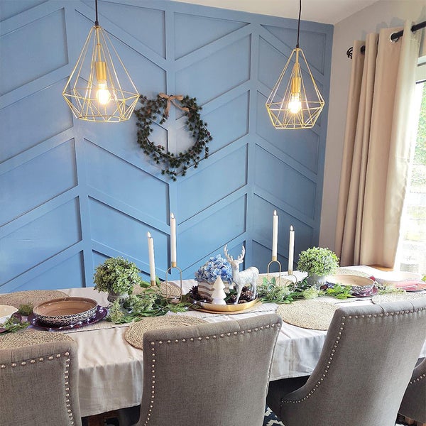 Festlich gedeckter Esstisch mit Dekoration, Pendelleuchten und Wandgestaltung