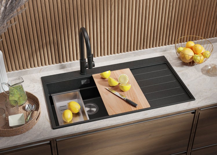 Küchenszene mit Spüle, Armatur, Schneidebrett und Zitronen auf einer Arbeitsplatte.