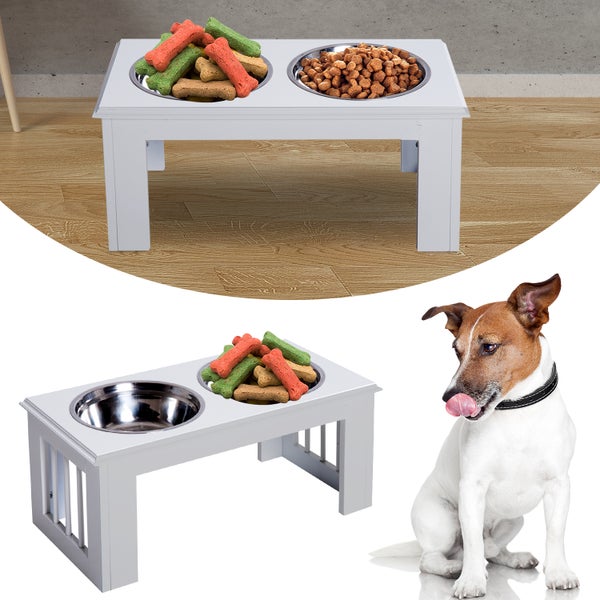 Erhöhte Hundenapfstation aus weißem Holz mit zwei Edelstahlnäpfen für Futter und Leckerlis, neben einem Jack Russell Terrier.