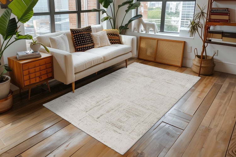 Helles Wohnzimmer mit einem rechteckigen Teppich mit geometrischem Muster auf einem Holzfußboden vor einem Sofa.