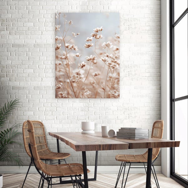 Wandbild mit floralem Motiv in einem Esszimmer mit Holztisch und Rattanstühlen vor einer weißen Backsteinwand
