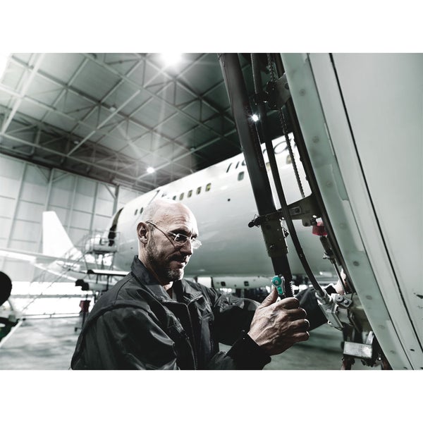 Ein Mechaniker bei der Wartung eines Flugzeugs in einem Hangar.
