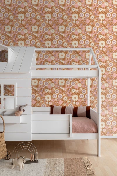 Vliestapete mit floralem Retro-Muster in einem hellen Kinderzimmer mit einem weißen Hausbett aus Holz.