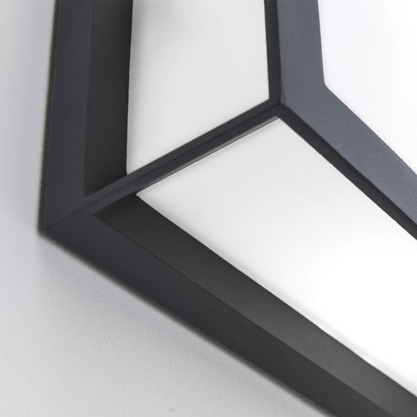 Nahaufnahme einer modernen Wandleuchte oder Deckenleuchte mit dunklem Metallrahmen und weißen Paneelen in geometrischer Form.