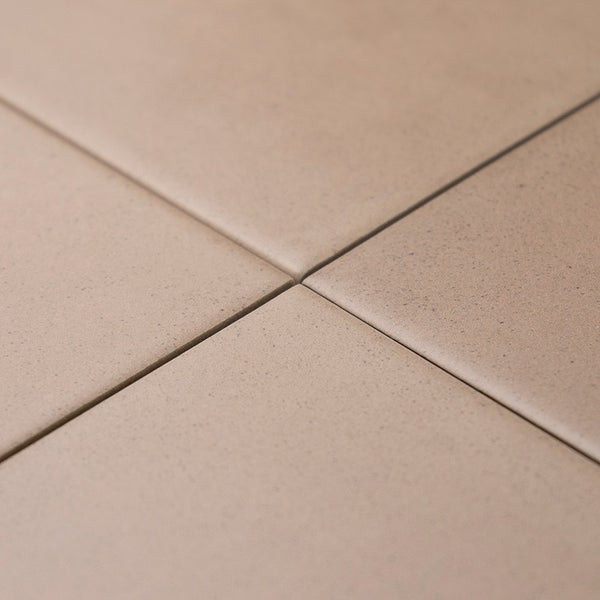 Quadratische Bodenfliesen mit feiner Textur und Fugenkreuz in einer Nahaufnahme