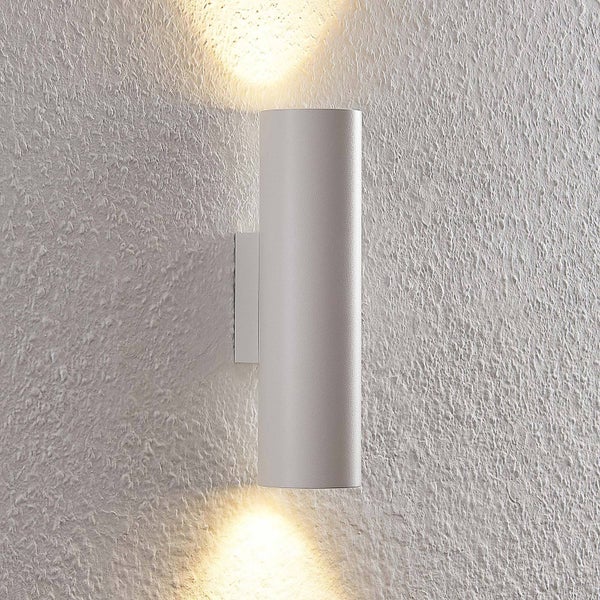 Weiße Wandleuchte mit Lichteffekt an einer strukturierten Wand