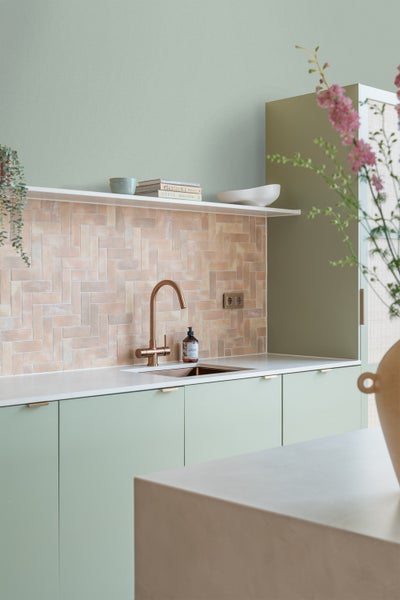 Helle Küche mit modernen Armaturen und Fliesen im Fischgrätmuster